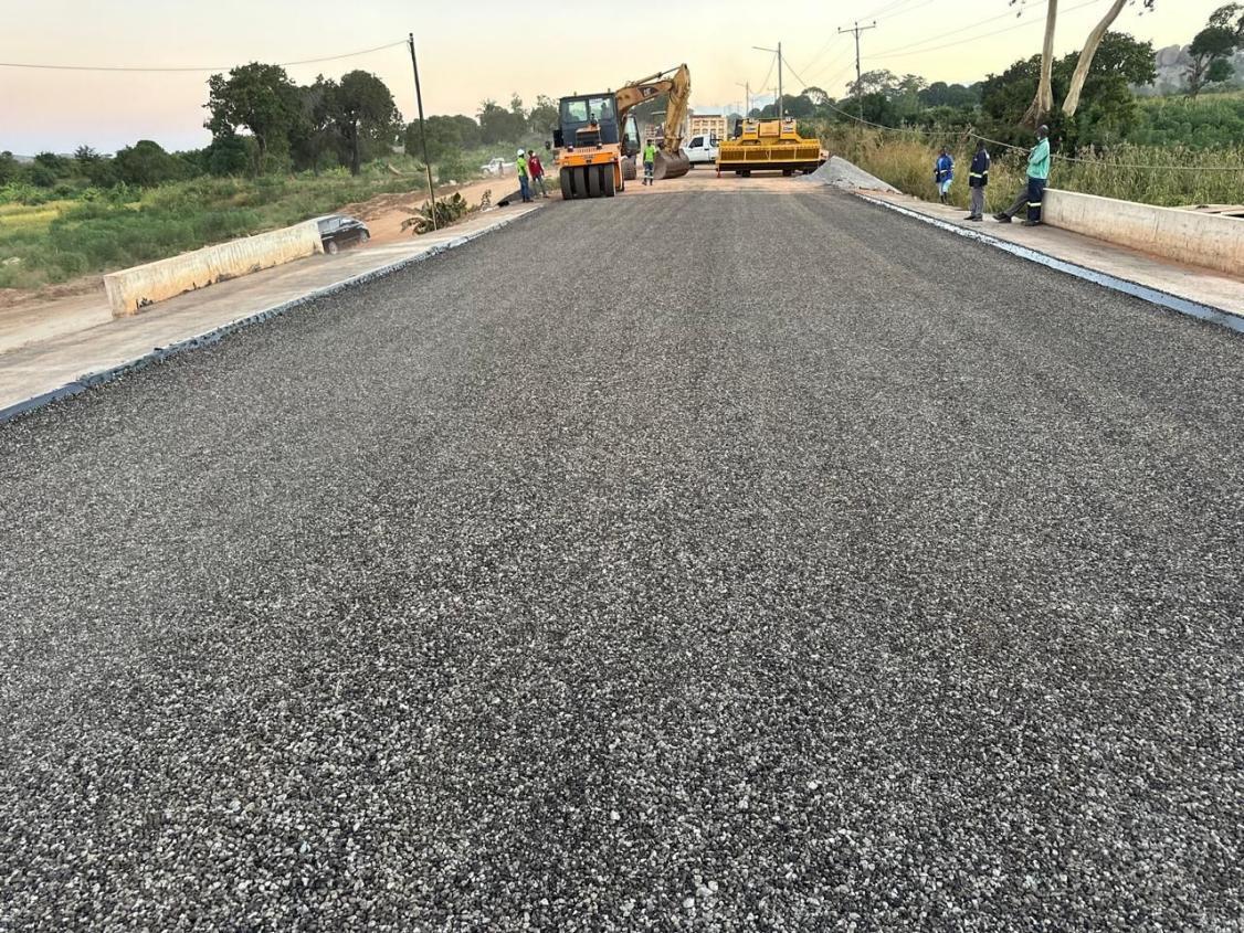 Obra de estrada em Angola com escavadora e preparação de base